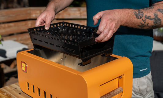 Ash box pulled from the Thaan Grill being emptied into a metal bucket