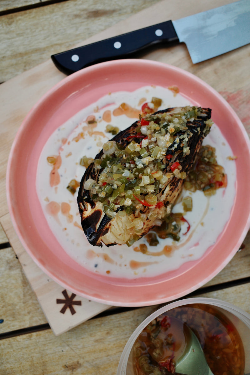 Charred cabbage wedges on a bed of honey yogurt, topped with glossy scallion-ginger chili oil and flaky salt