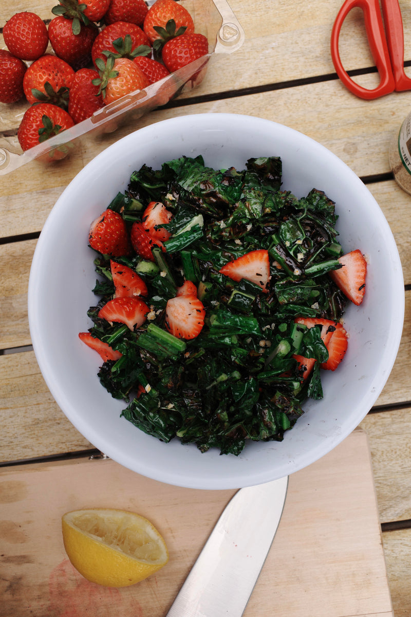 alt text	Charred lacinato kale salad with sliced strawberries and lemon-honey vinaigrette in a serving bowl